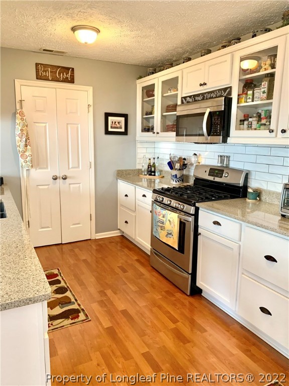 4481 Virsalli Loop Hope Mills, NC 28348 - Photo 3 of 24 a kitchen with stainless steel appliances granite countertop a stove a sink and a microwave