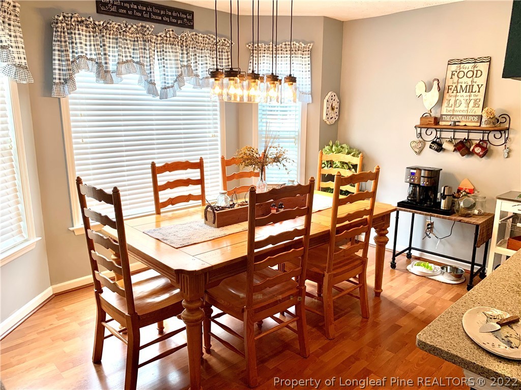 4481 Virsalli Loop Hope Mills, NC 28348 - Photo 5 of 24 a view of a dining room with furniture a chandelier and wooden floor
