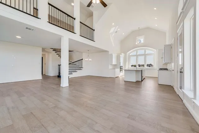 a view of a big room with wooden floor and windows
