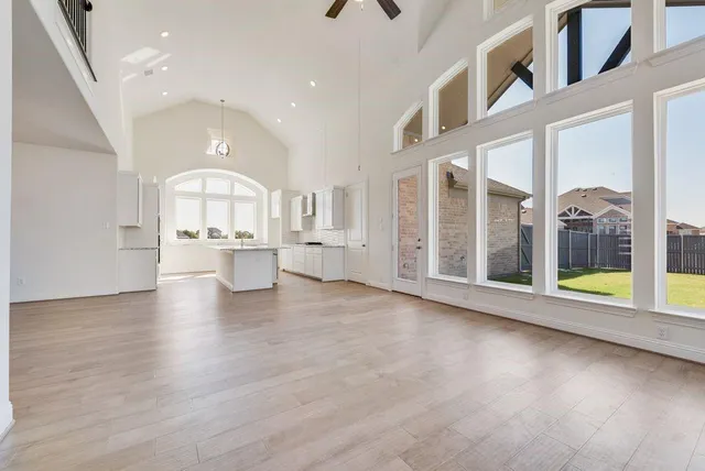 a large white kitchen with kitchen island a sink a stove and white cabinets