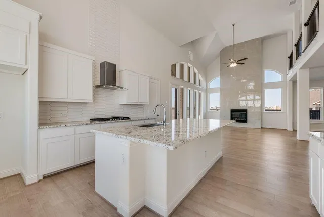 a large kitchen with stainless steel appliances granite countertop a sink and cabinets
