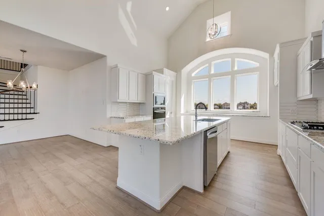 a kitchen with granite countertop a sink stove and cabinets