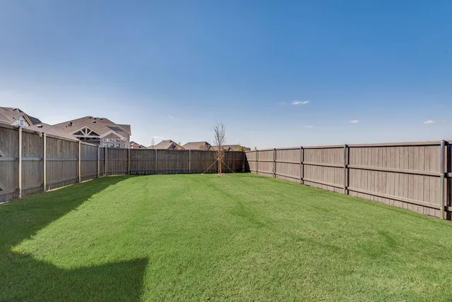 a view of a house with a big yard and large trees