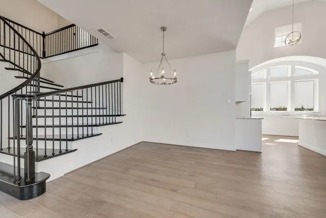 a view of a livingroom with wooden floor and a staircase