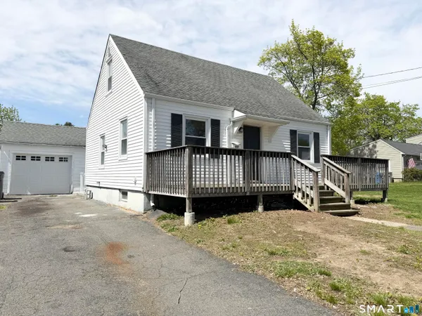 a view of a house with wooden deck front of house