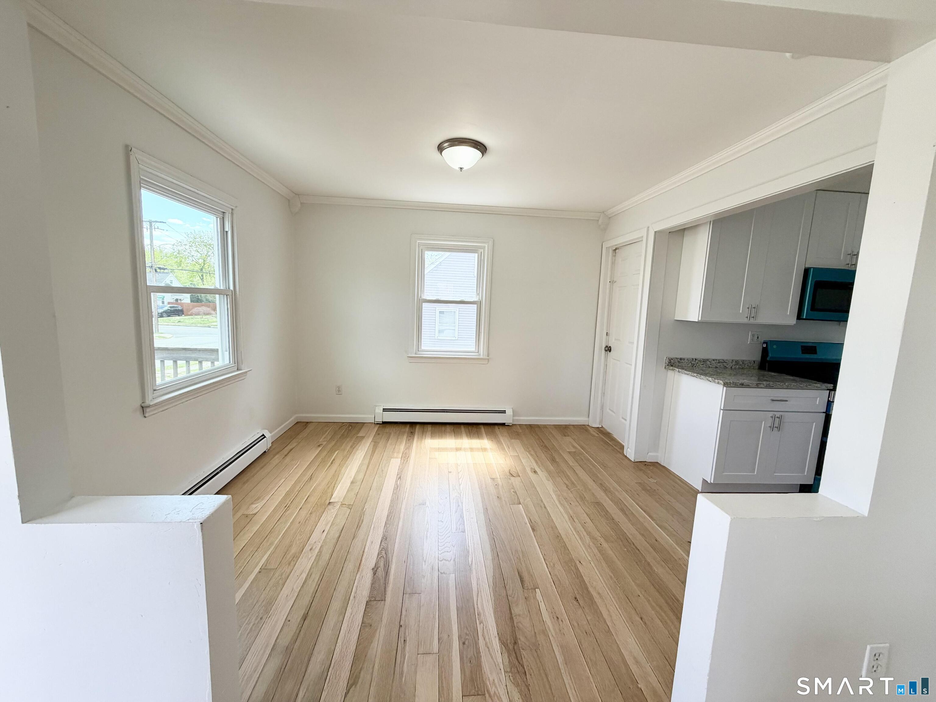 102 Benham Street Bristol, CT 06010 - Photo 11 of 17 wooden floor in an empty room with a window