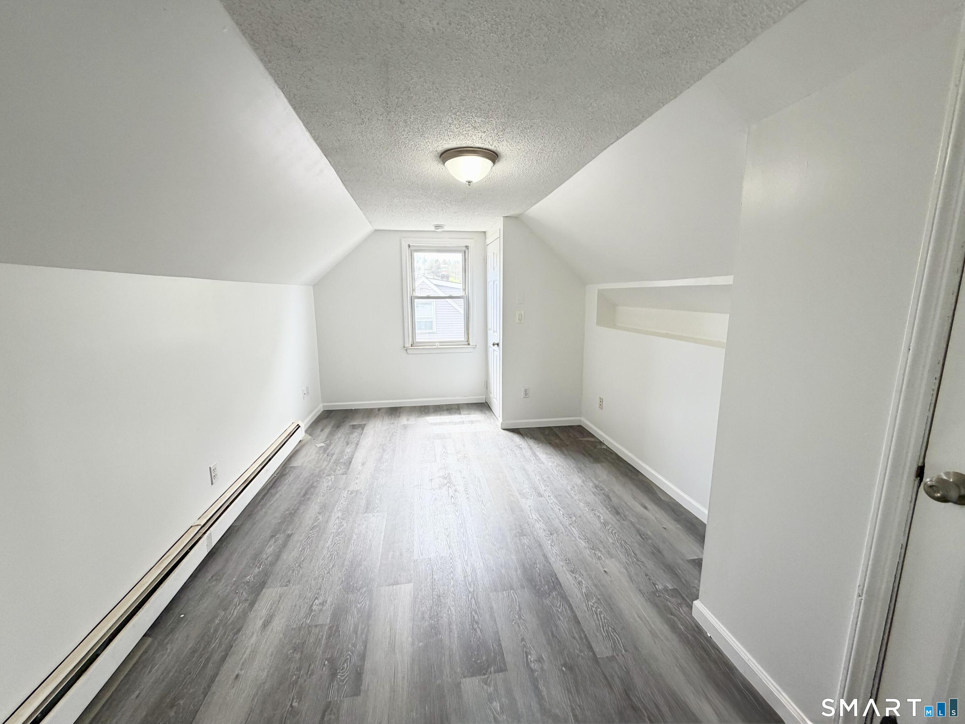 102 Benham Street Bristol, CT 06010 - Photo 12 of 17 wooden floor in an empty room with a window