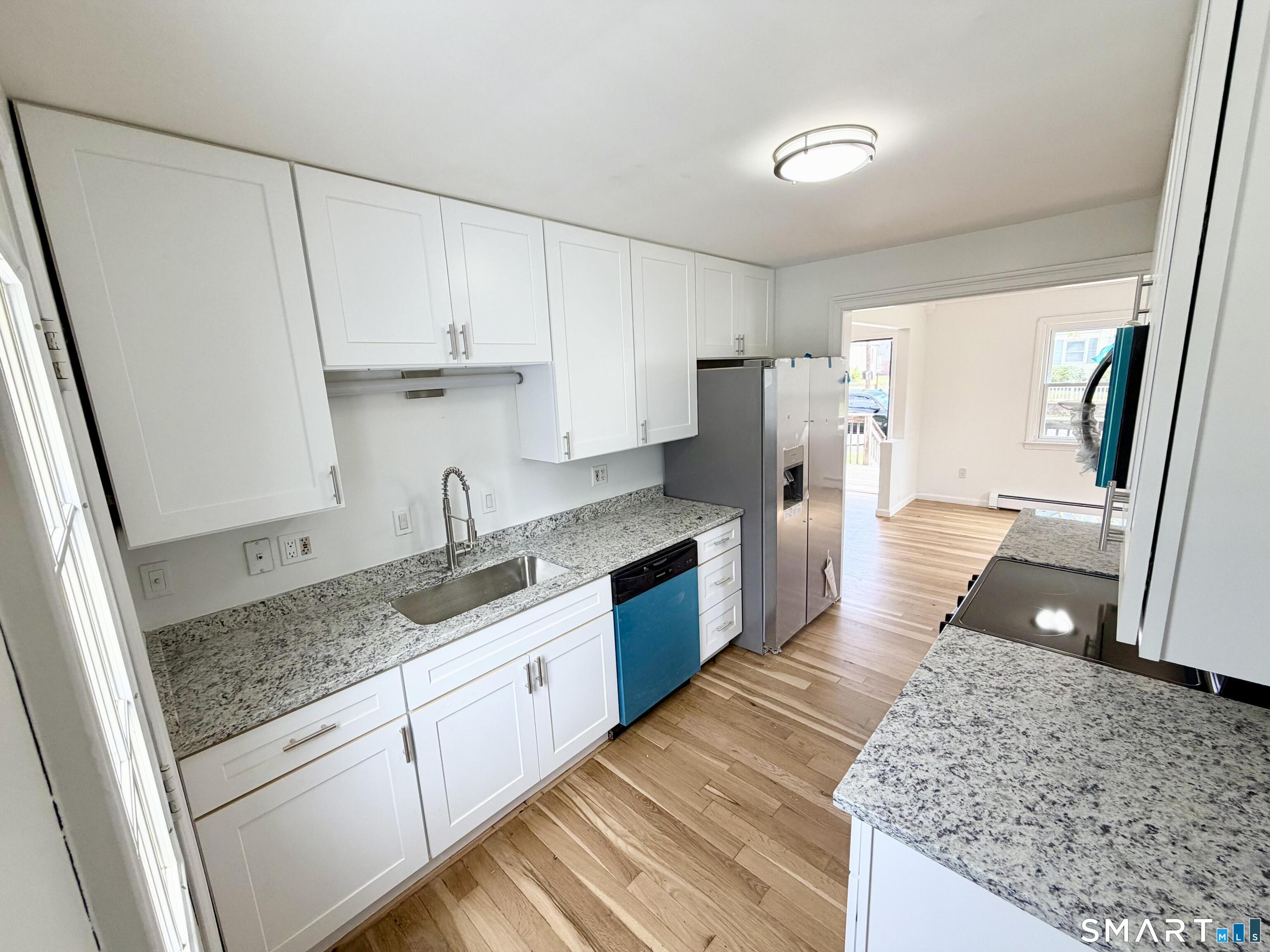 102 Benham Street Bristol, CT 06010 - Photo 6 of 17 a kitchen with granite countertop a sink stove and refrigerator