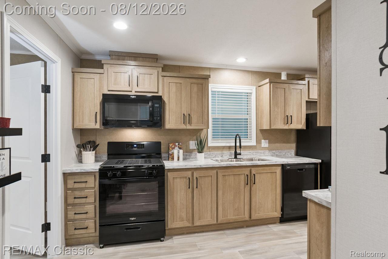 7105 West Vienna Road Clio, MI 48420 - Photo 4 of 23 Kitchen featuring wood-finish cabinetry, black appliances, a black gooseneck faucet, light-toned countertops, and wood-finish flooring