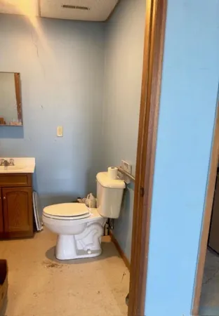 a white toilet sitting next to a shower