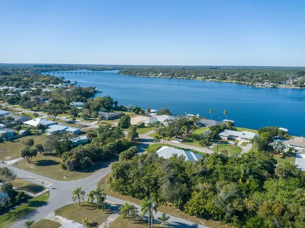 an aerial view of a house with a yard and lake view