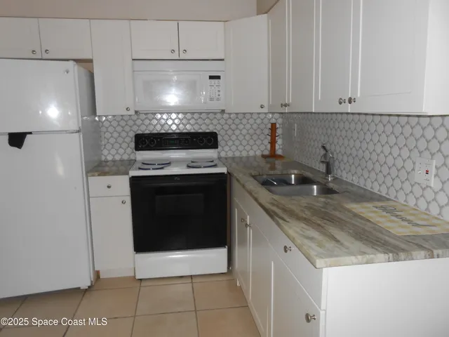 a kitchen with granite countertop a stove sink and cabinets
