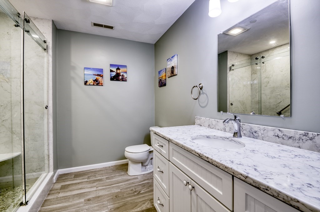 159 Allen Road, Unit 24 Billerica, MA 01821 - Photo 18 of 34 a bathroom with a granite countertop toilet sink and a mirror