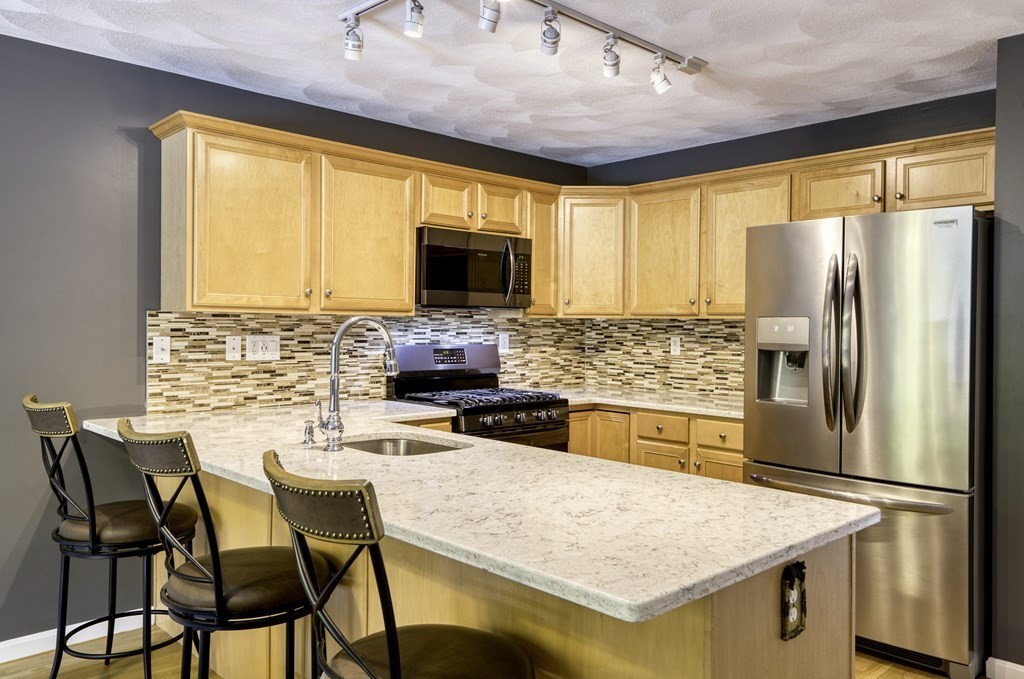 159 Allen Road, Unit 24 Billerica, MA 01821 - Photo 3 of 34 a kitchen with stainless steel appliances granite countertop a stove refrigerator and a view of living room