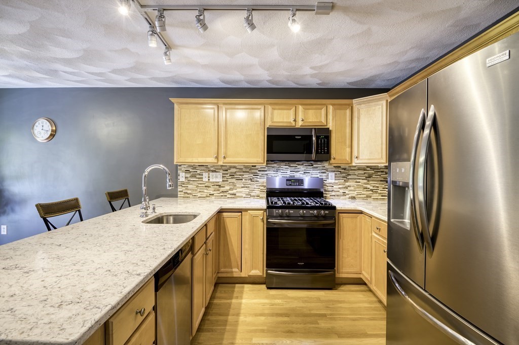 159 Allen Road, Unit 24 Billerica, MA 01821 - Photo 4 of 34 a kitchen with stainless steel appliances granite countertop a refrigerator a stove a sink and a microwave