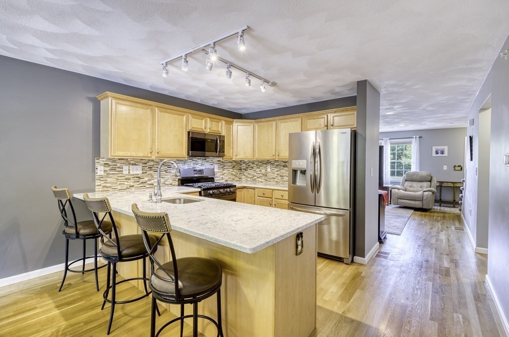 159 Allen Road, Unit 24 Billerica, MA 01821 - Photo 5 of 34 a kitchen with a table chairs refrigerator and cabinets
