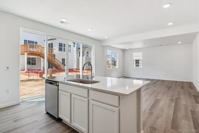 a kitchen with stainless steel appliances granite countertop a sink and dishwasher with wooden floor