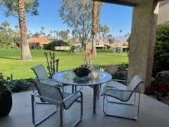a view of a patio with table and chairs potted plants with wooden floor and lake view