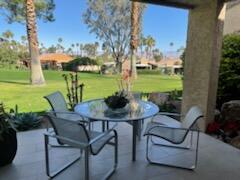 73446 Dalea Lane Palm Desert, CA 92260 - Photo 1 of 17 a view of a patio with table and chairs potted plants with wooden floor and lake view