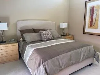 a bed sitting in a bedroom next to a lamp