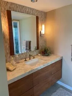 a bathroom with a granite countertop sink and a mirror