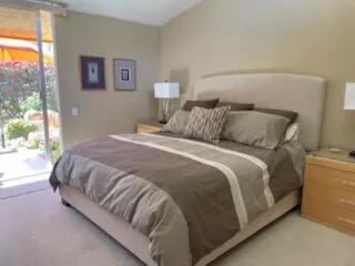 a large bed sitting in a bedroom next to a window