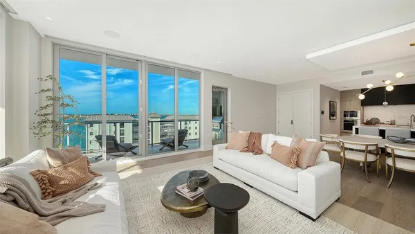 a living room with furniture and a floor to ceiling window