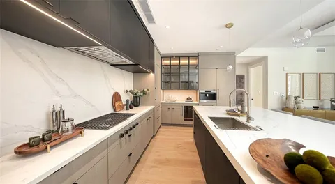 a large kitchen with kitchen island stainless steel appliances a sink a counter top space and cabinets