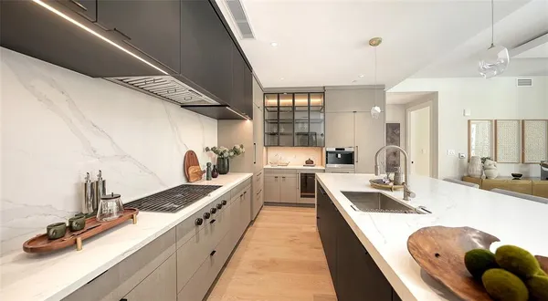a large kitchen with kitchen island stainless steel appliances a sink a counter top space and cabinets