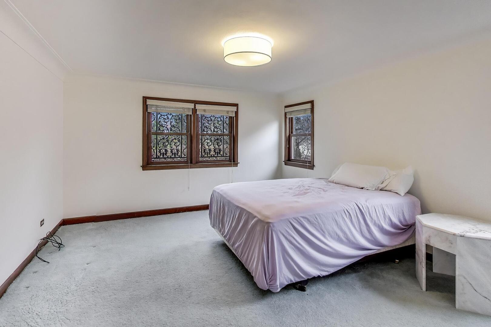 1115 North Ridgeland Avenue Oak Park, IL 60302 - Photo 16 of 40 a spacious bedroom with a bed and a lamp