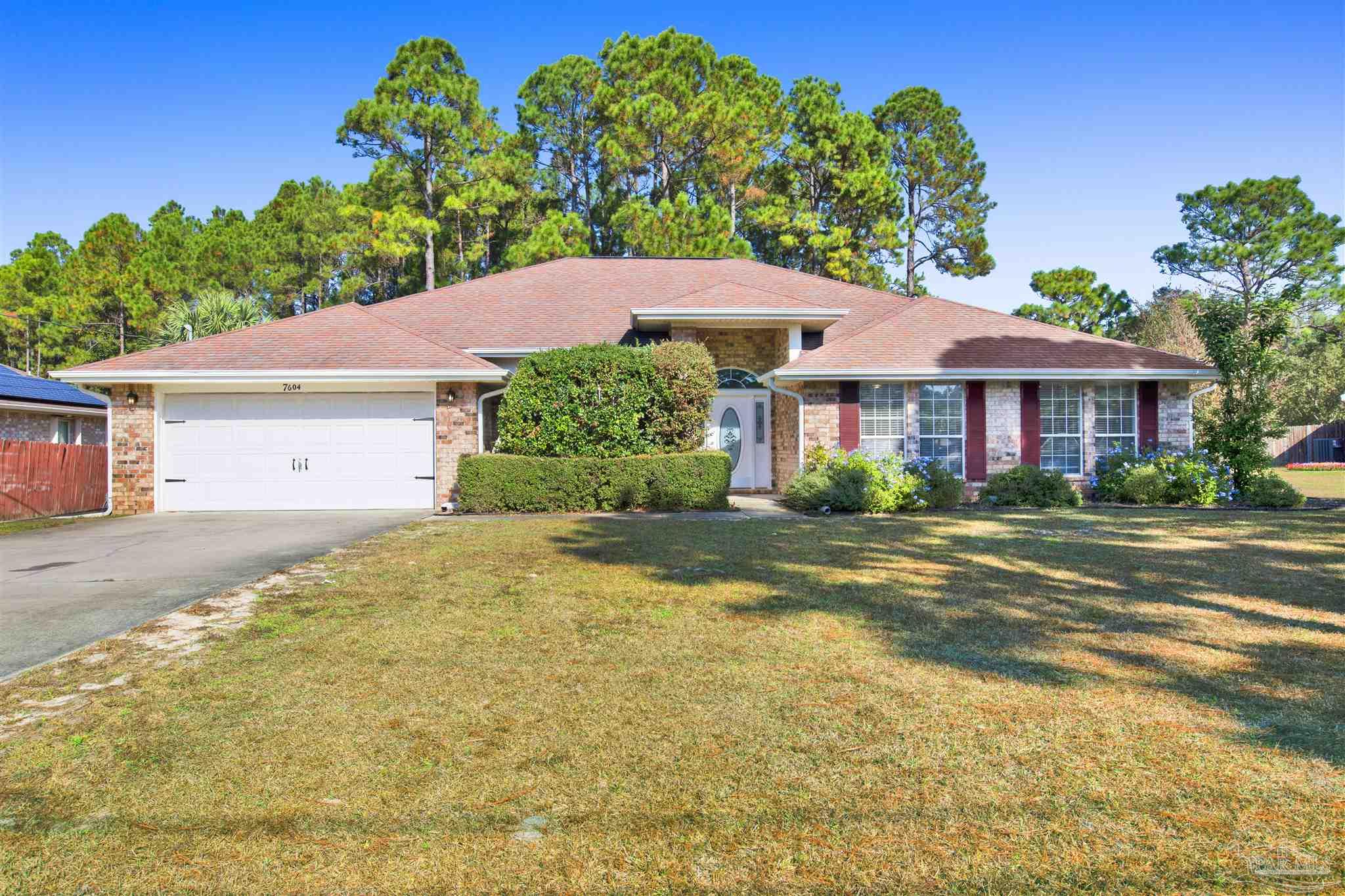 a view of a house with a yard and potted plants