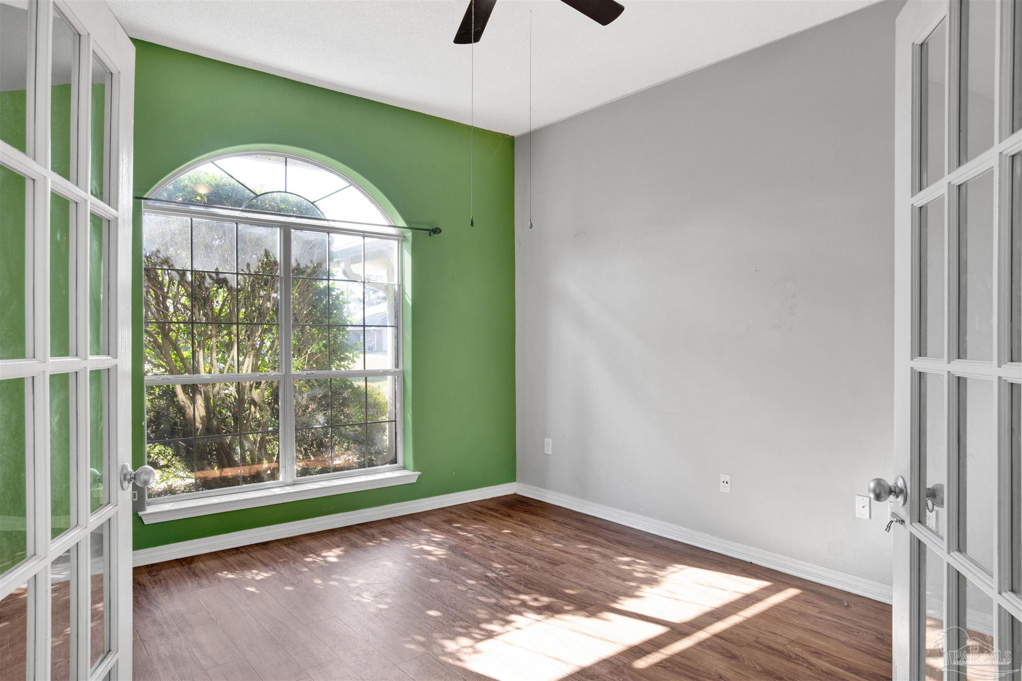 7604 Brewster Street Navarre, FL 32566 - Photo 12 of 36 a view of empty room with wooden floor and fan