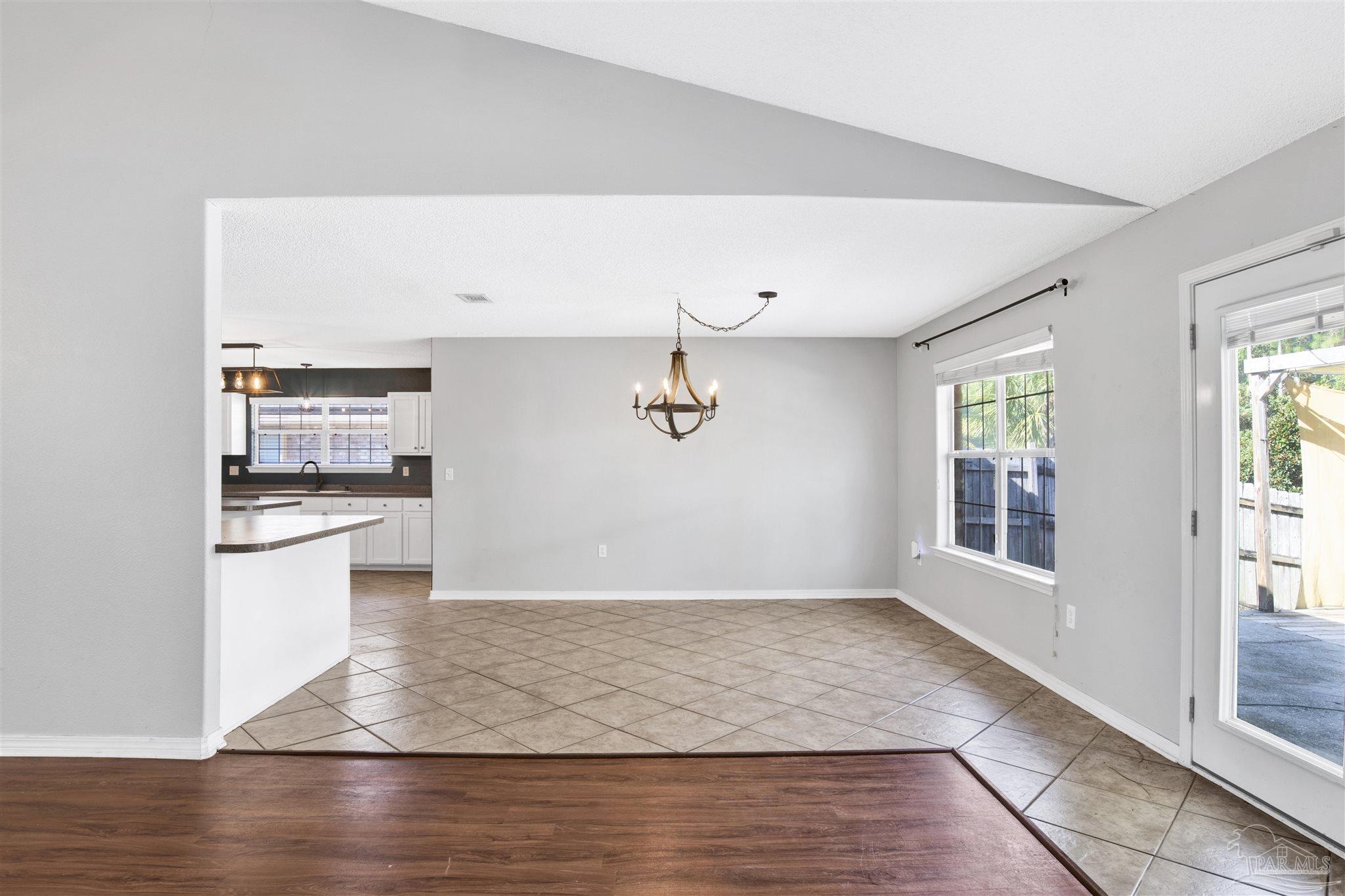 7604 Brewster Street Navarre, FL 32566 - Photo 15 of 36 a view of a kitchen with wooden floor and a window
