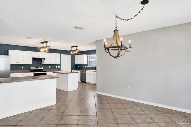 a kitchen with stainless steel appliances granite countertop a sink a stove top oven a counter space and cabinets