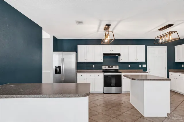 a kitchen with stainless steel appliances granite countertop a refrigerator a stove top oven a sink and dishwasher