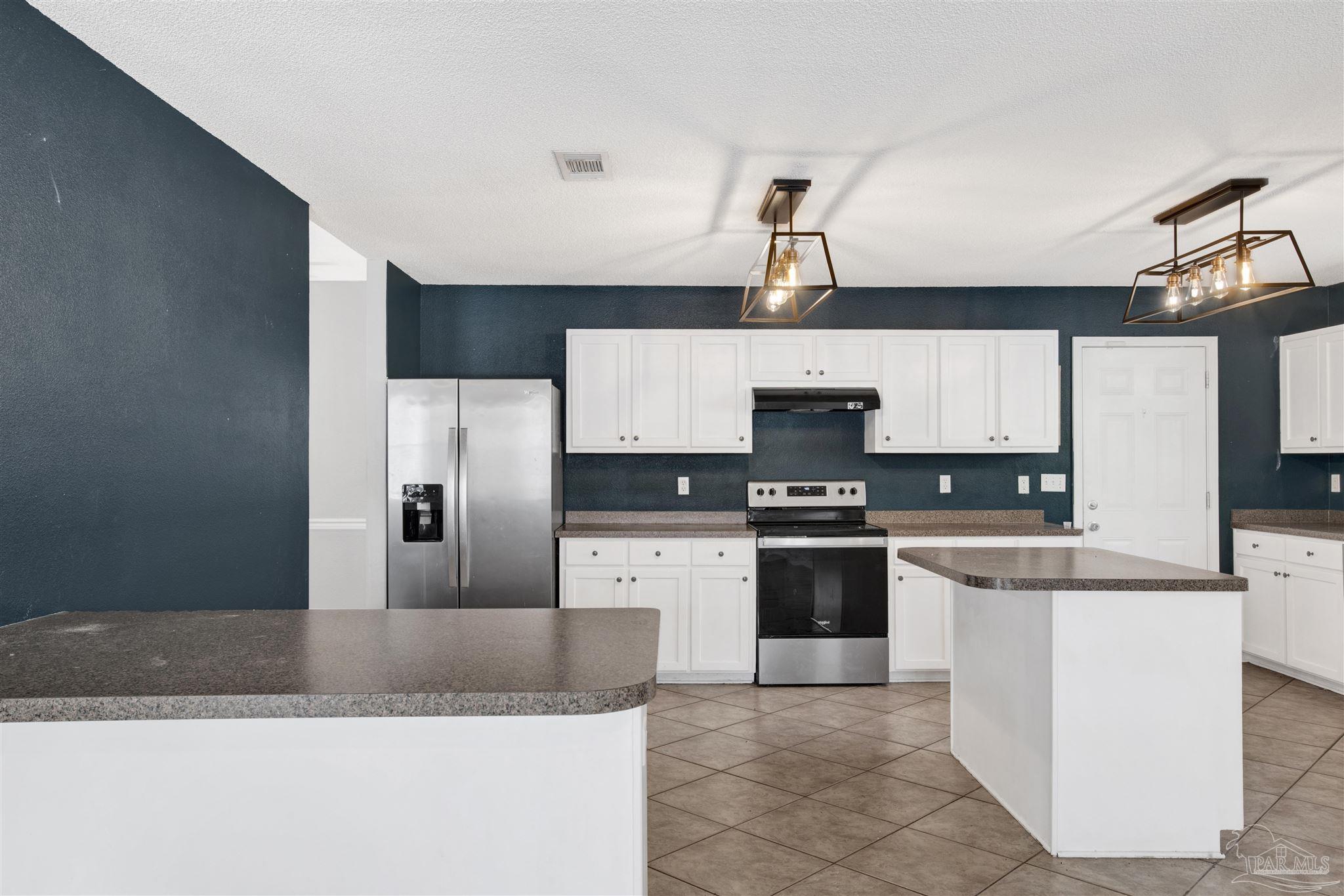 7604 Brewster Street Navarre, FL 32566 - Photo 17 of 36 a kitchen with stainless steel appliances granite countertop a refrigerator a stove top oven a sink and dishwasher