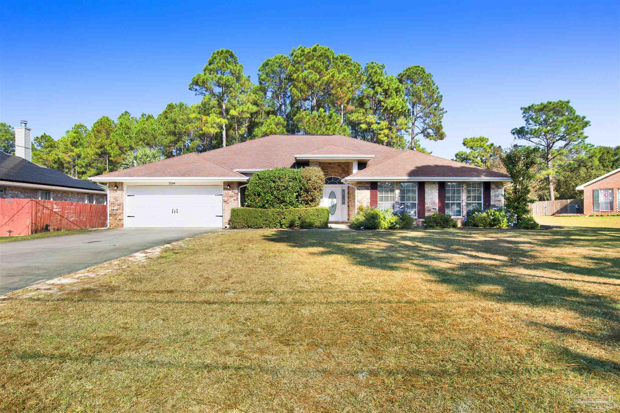7604 Brewster Street Navarre, FL 32566 - Photo 2 of 36 a front view of a house with a yard