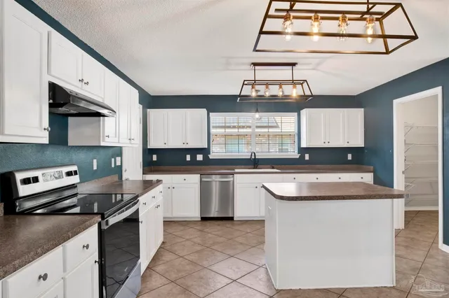 a kitchen with stainless steel appliances granite countertop a sink stove and cabinets