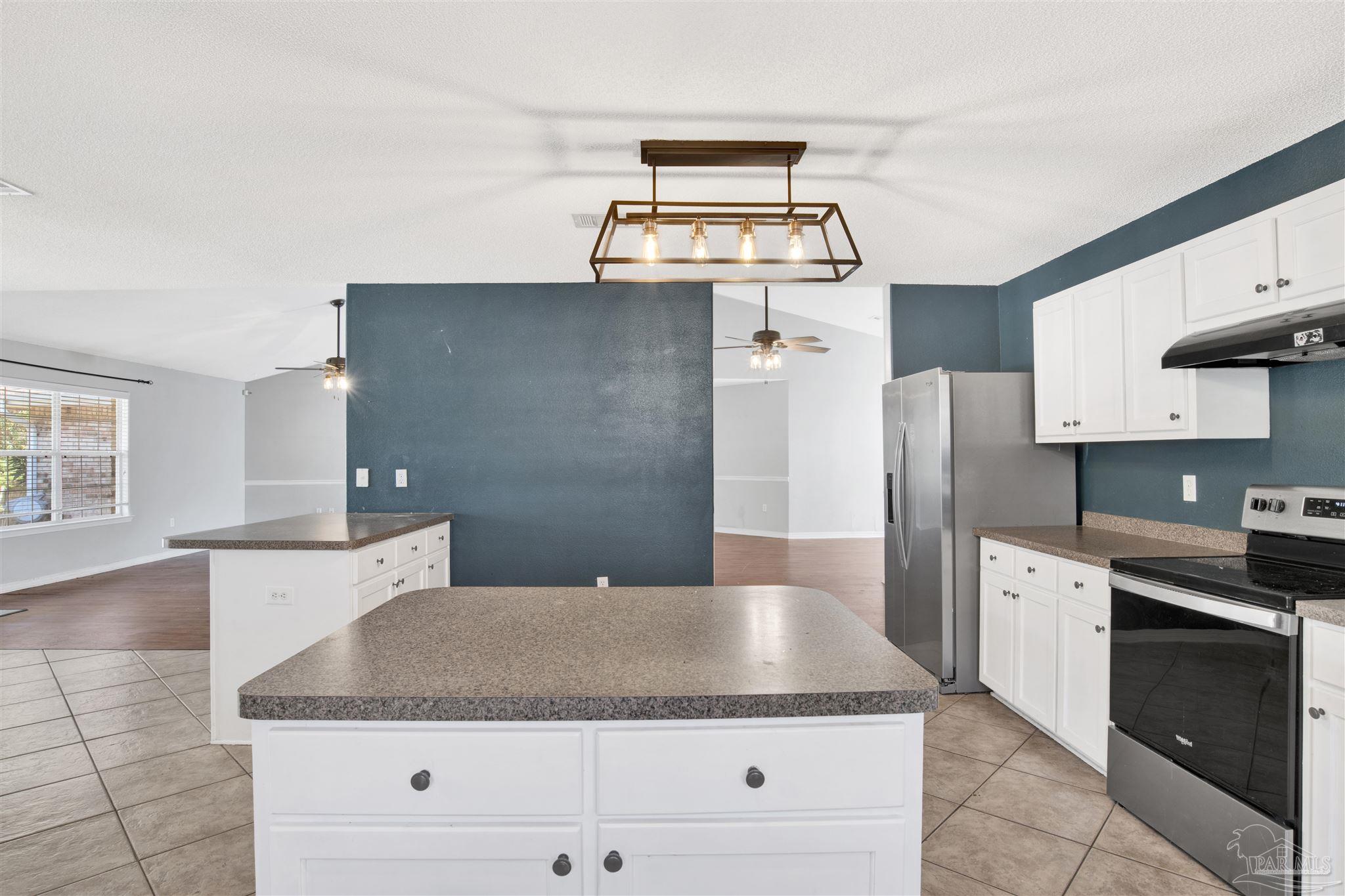 7604 Brewster Street Navarre, FL 32566 - Photo 25 of 36 a kitchen with cabinets and stainless steel appliances