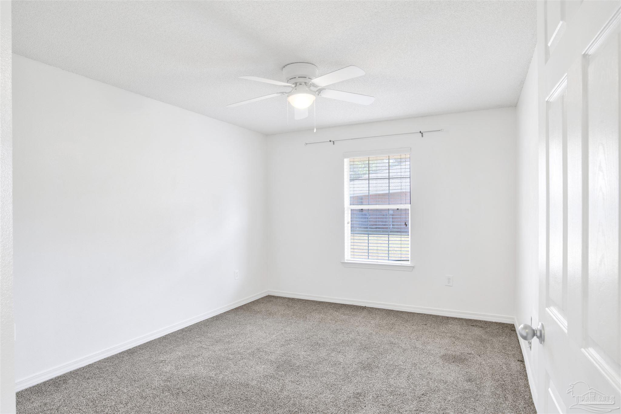 7604 Brewster Street Navarre, FL 32566 - Photo 28 of 36 an empty room with a window and a fan