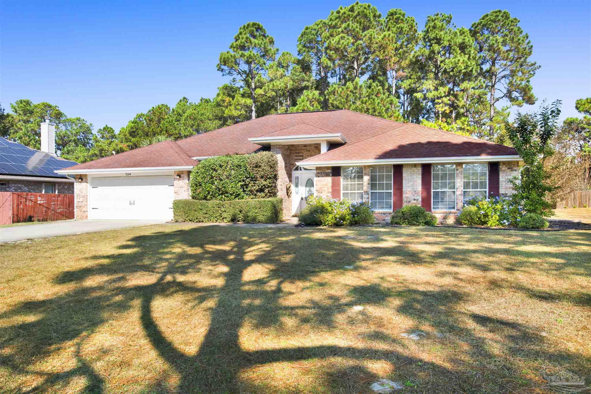 7604 Brewster Street Navarre, FL 32566 - Photo 3 of 36 a front view of a house with a yard