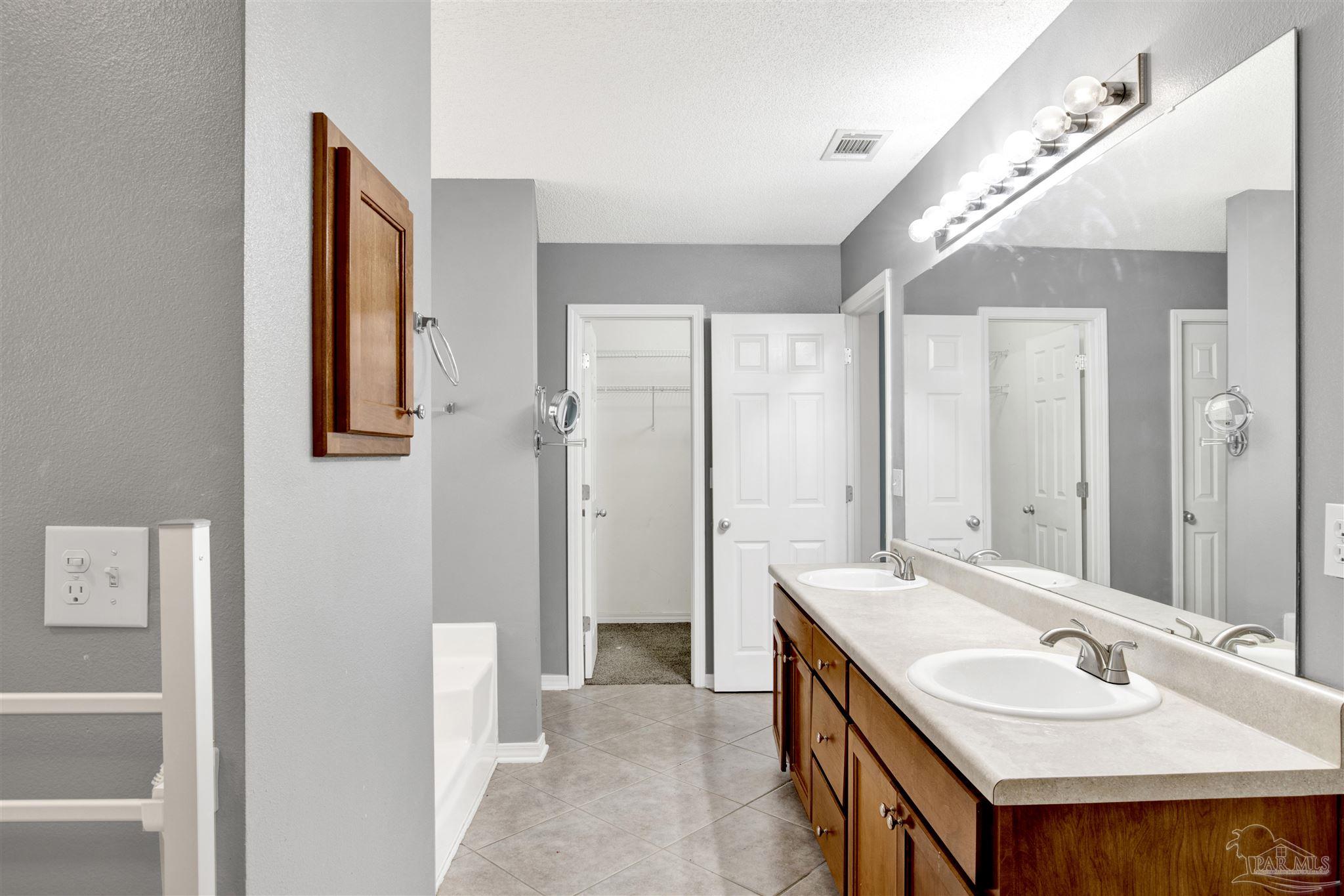 7604 Brewster Street Navarre, FL 32566 - Photo 34 of 36 a bathroom with a sink double vanity and a mirror