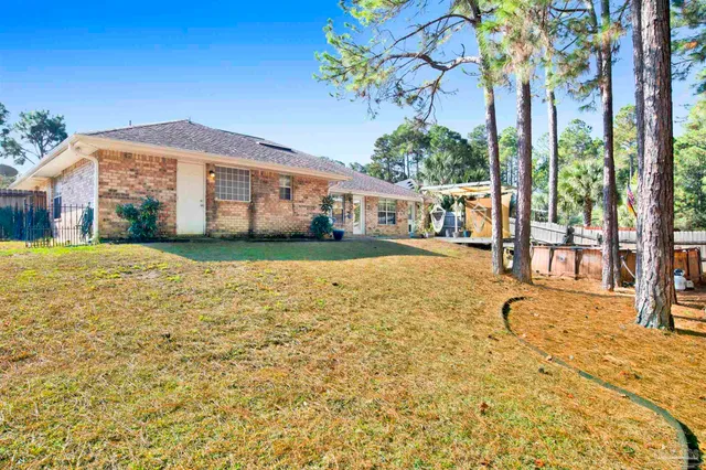 a view of a house with a yard and potted plants