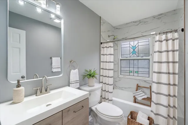 a bathroom with a sink toilet a mirror and shower