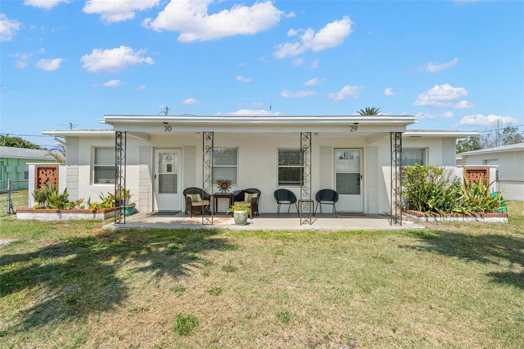 a view of a house with backyard and a tree
