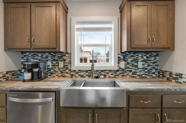 a kitchen with granite countertop a stove sink and cabinets