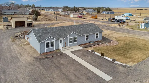 an aerial view of a house with table and chairs