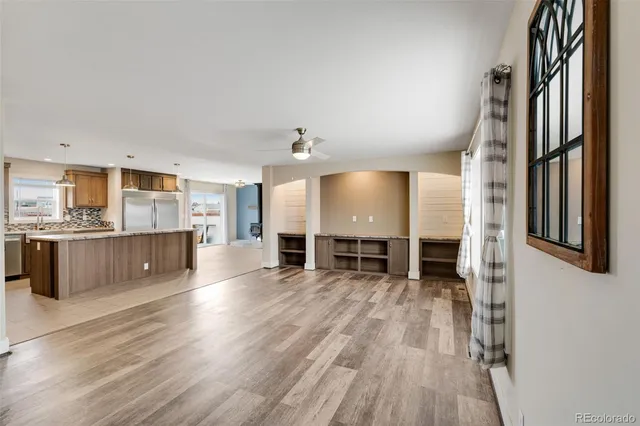 an empty room with windows cabinet and fireplace