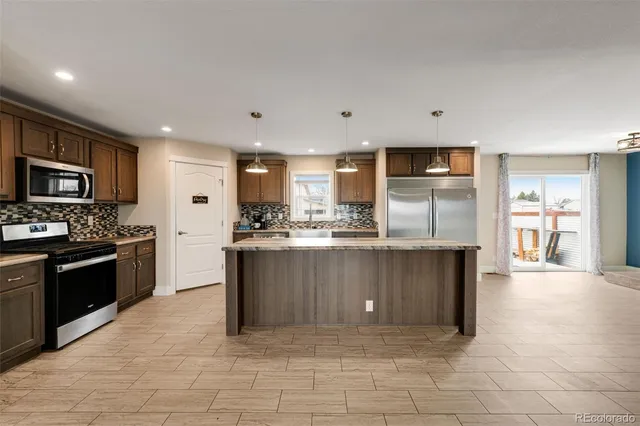 a kitchen with a refrigerator a sink and cabinets