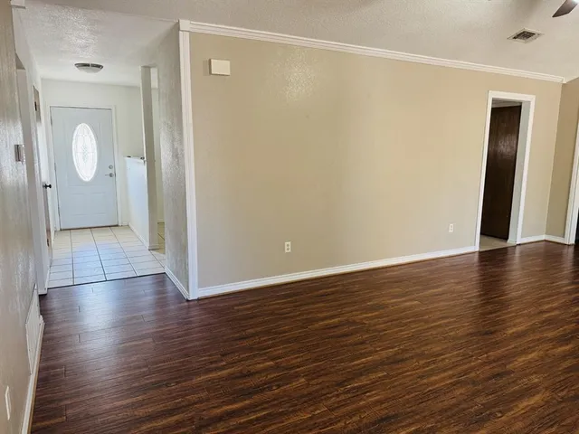 a view of a room with wooden floor and mirror